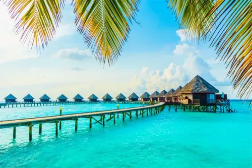 Row of overwater bungalows on a sunny day in the Maldives, a top December destination